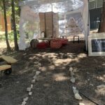 The Stone Leaf Tea Company's tent with a table and shelf of their tea cups