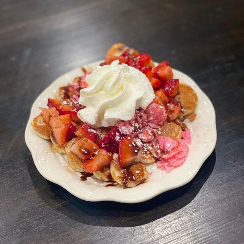 Crepe covered with strawberries, whipped cream, and powdered sugar